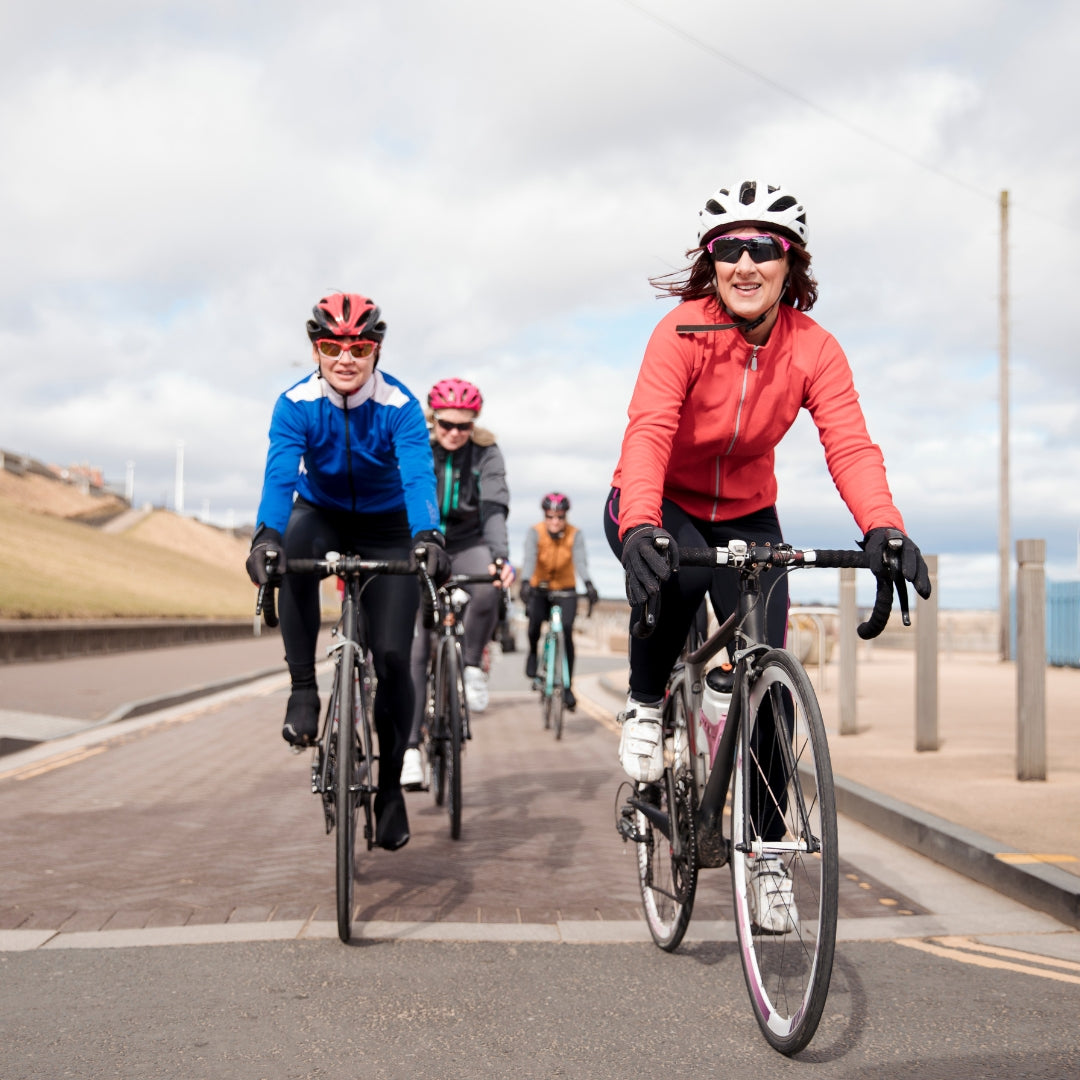 Group of cyclists riding on a road with a scenic background