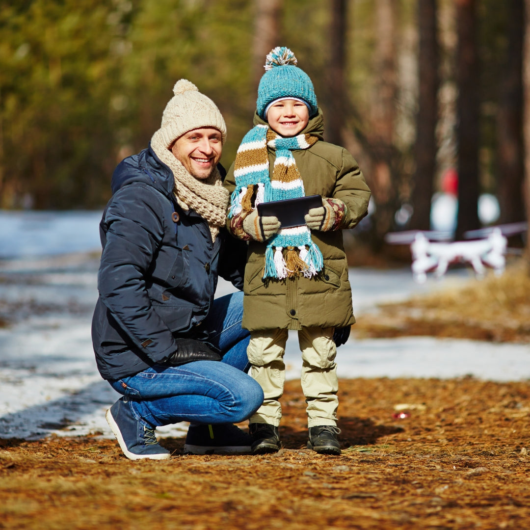 Man and child in winter clothing by a body of water