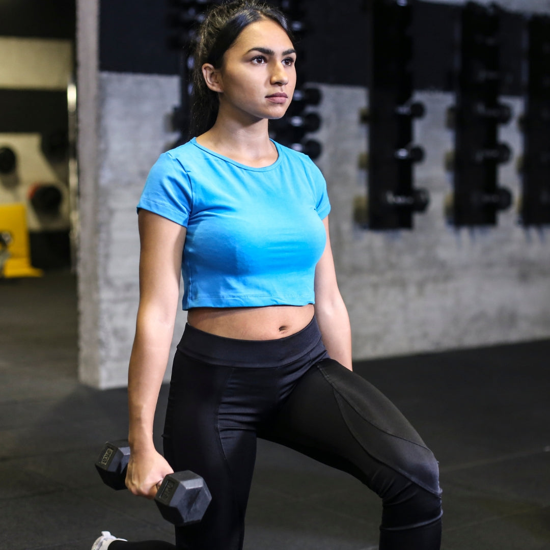 Woman exercising with dumbbells in a gym setting